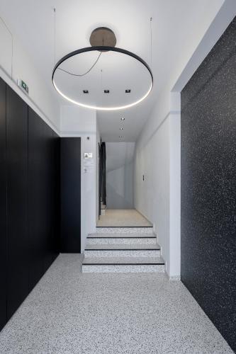 a hallway with stairs and a large light fixture at Filopappou Hill Suites by Athens Stay in Athens