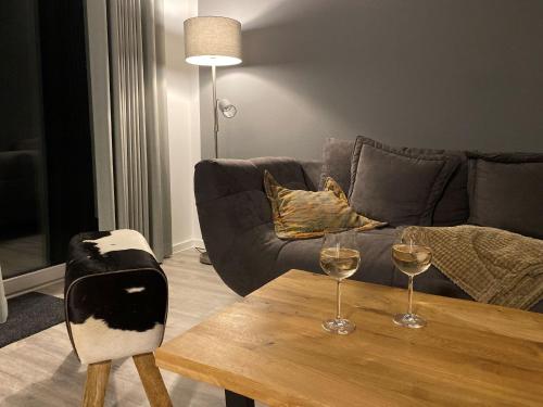 Sala de estar con mesa y 2 copas de vino en Ferienhaus Diemelblick en Heringhausen