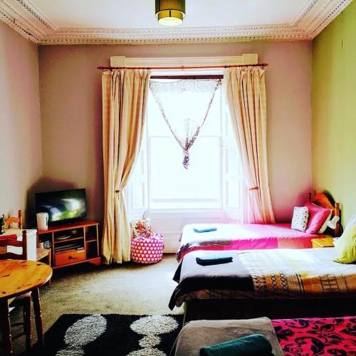 a living room with two beds and a window at aabAlree Guest House in Dundee