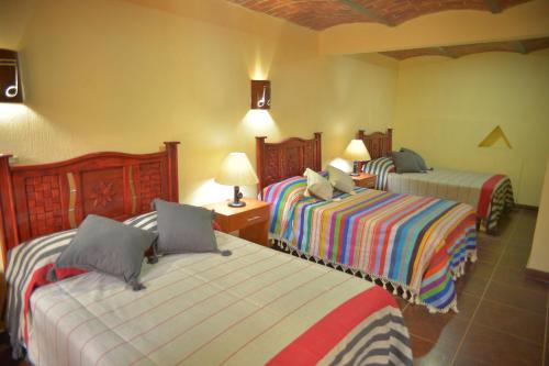 a hotel room with two beds and two lamps at OYO Hotel Castillo Santa Cecilia in Tapalpa