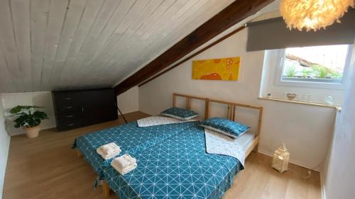 Apartment Carina في كوبر: غرفة نوم بسرير لحاف ازرق ونافذة