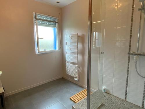 a bathroom with a shower and a window at Magnifique Maison face à l'Océan - Pointe du RAZ in Penharn