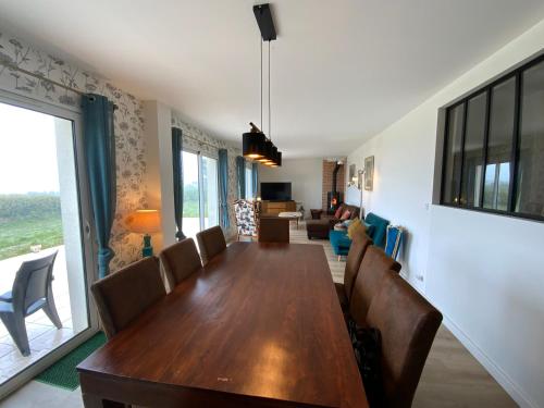 une salle à manger avec une table et des chaises en bois dans l'établissement Magnifique Maison face à l'Océan - Pointe du RAZ, à Penharn