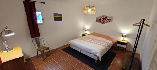 a bedroom with a bed and a table and a lamp at Mas Christine in Buis-les-Baronnies
