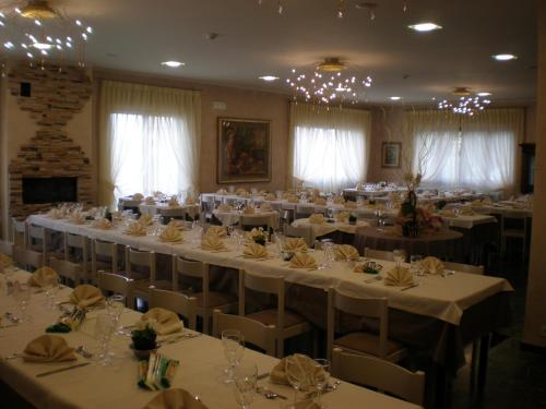 une salle de banquet avec tables et chaises et nappes blanches dans l'établissement Hotel Marcellino, à Selvino