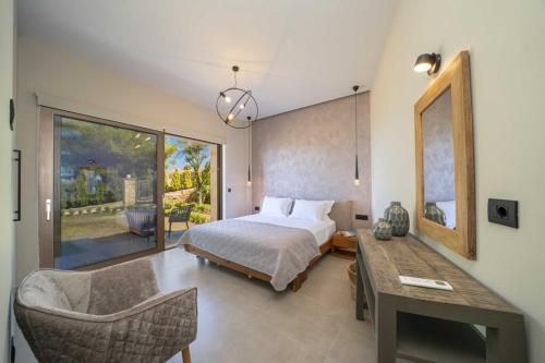 a bedroom with a bed and a table and a chair at Narcissos Villa in Argostoli