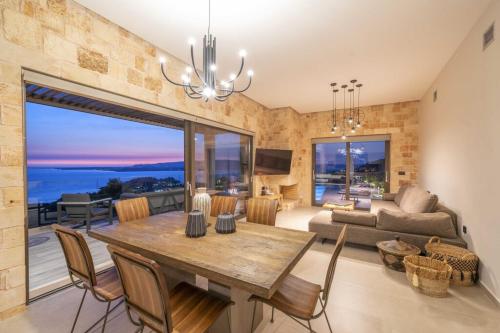 a dining room with a table and a living room at Narcissos Villa in Argostoli