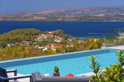 a large swimming pool with a view of the water at Narcissos Villa in Argostoli