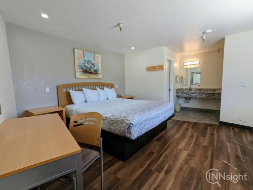 a hotel room with a bed and a table at Royal Inn in South San Francisco