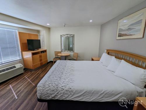 a hotel room with a bed and a television at Royal Inn in South San Francisco