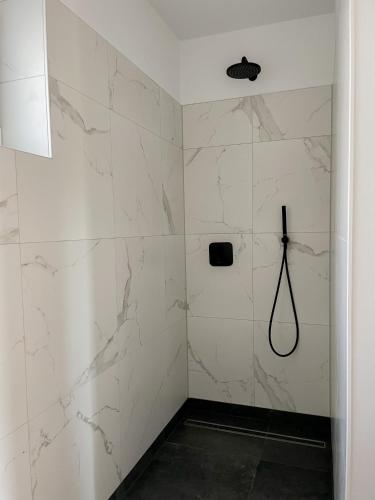 a bathroom with a shower with white marble walls at Ferienwohnung The Hideaway in Scharbeutz