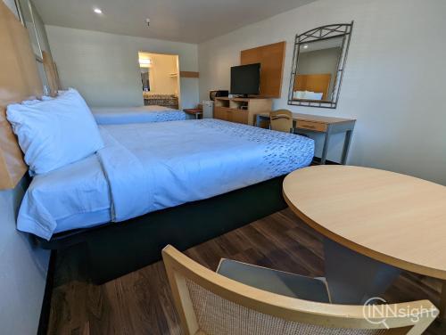 a hotel room with a bed and a table at Royal Inn in South San Francisco