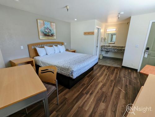 a hotel room with a bed and a table at Royal Inn in South San Francisco