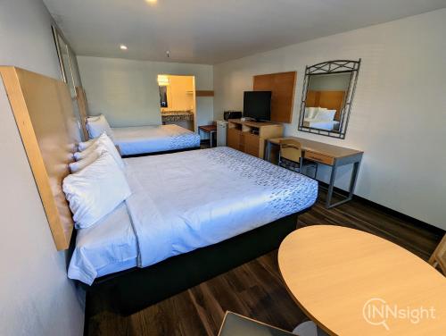 a hotel room with two beds and a desk at Royal Inn in South San Francisco