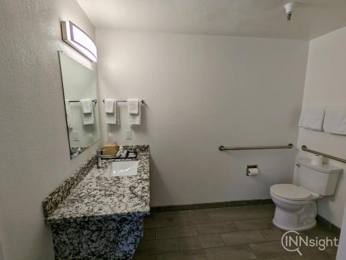 a bathroom with a toilet and a sink and a mirror at Royal Inn in South San Francisco