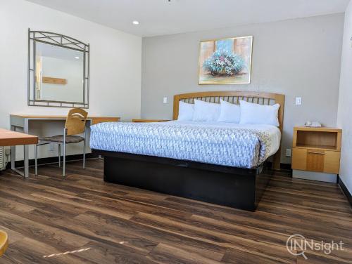 a hotel room with a bed and a desk at Royal Inn in South San Francisco