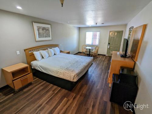 a bedroom with a bed and a desk and a television at Royal Inn in South San Francisco