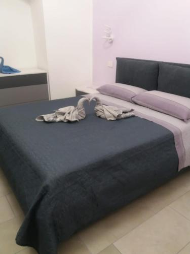 een groot bed in een slaapkamer met paarse lakens bij Sara Suite - Holiday Home in Bernalda