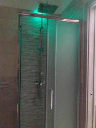 een douche in een badkamer met een groen licht bij Sara Suite - Holiday Home in Bernalda