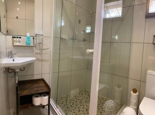 a bathroom with a glass shower and a sink at Orange Breeze Self-Catering Apartment in Kakamas