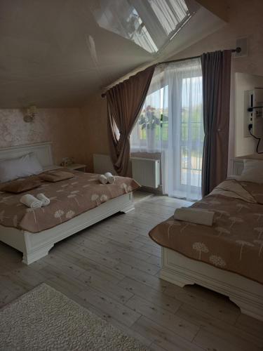 a bedroom with two beds and a large window at DALIM in Duliby