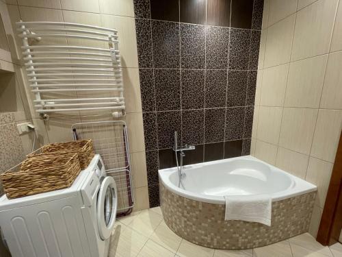 łazienka z wanną i toaletą w obiekcie AL-DOM Apartament Ogrodowa Bocianie Gniazdo z garażem w Kołobrzegu