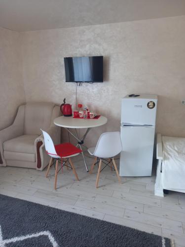 a kitchen with a table and a white refrigerator at DALIM in Duliby