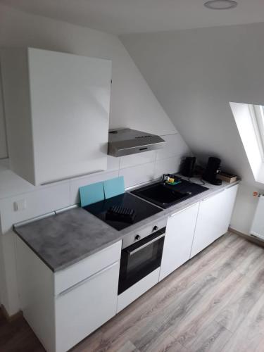 uma cozinha branca com um fogão e um lavatório em Ferienwohnung Apartment - Free Parking - WiFi - Kitchen em Essen