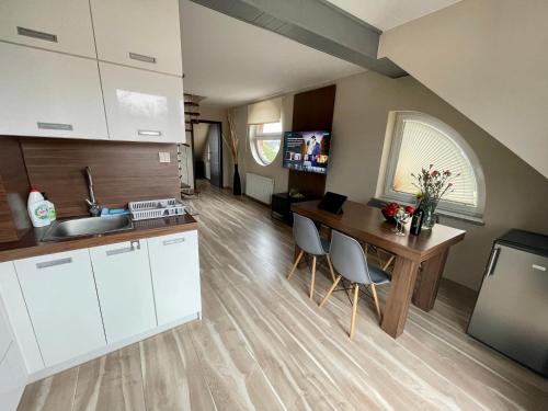 a kitchen with white cabinets and a wooden table at Baltic Sun SPA in Rewal