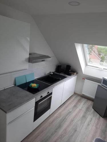 a kitchen with white cabinets and a sink and a window at Ferienwohnung Apartment - Free Parking - WiFi - Kitchen in Essen