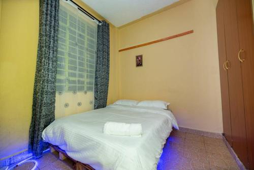 a bedroom with a bed with two towels on it at Repose Stay - Karen, 2 Bedroom, WiFi,Parking, CCTV in Nairobi