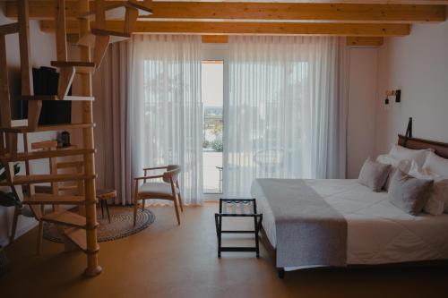 a bedroom with a bed and a ladder and a window at Casinhas de Santo António in Alter do Chão
