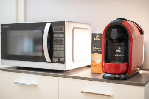 a microwave and a coffee maker on a counter at Chillzimmer in Duisburg