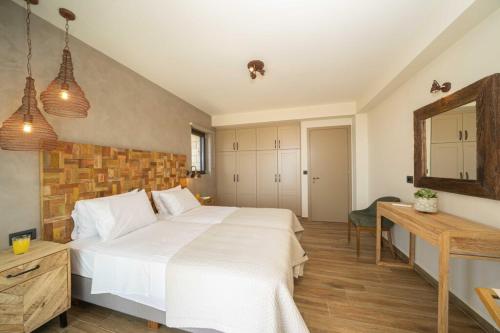 a bedroom with a large white bed and a mirror at Echos Villa in Argostoli