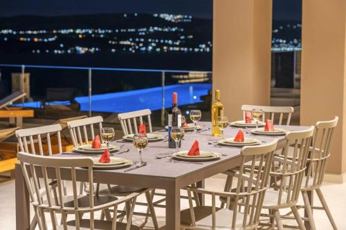 a table with chairs and a table with wine glasses at Echos Villa in Argostoli