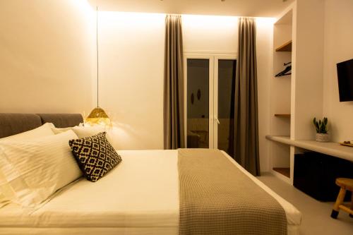 a bedroom with a bed with a pillow on it at Eleana Hotel in Tinos Town