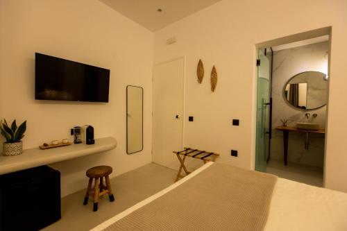 a bedroom with a bed and a tv on the wall at Eleana Hotel in Tinos Town