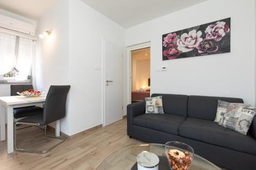 salon z kanapą i stołem w obiekcie Apartman Ruza w Krku