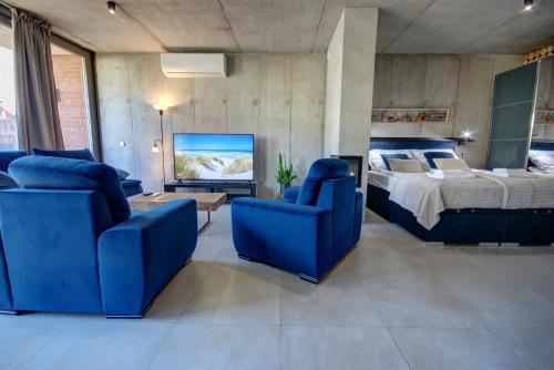 a bedroom with two blue chairs and a bed at HelApart - Loft in Hel