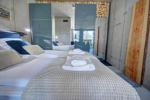 a room with three beds with towels on them at HelApart - Loft in Hel