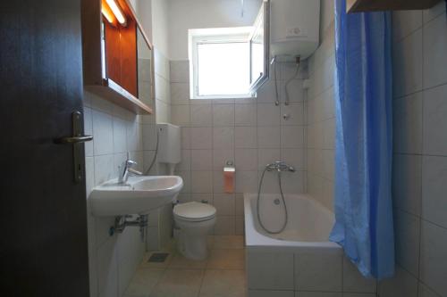 a bathroom with a sink and a toilet and a bath tub at Apartment Franjo in Malinska