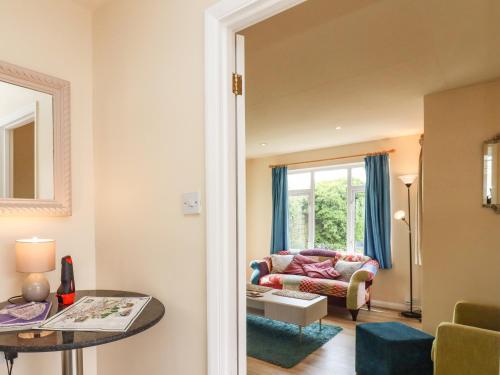 a living room with a couch and a table at Straw Cottage in Swindon