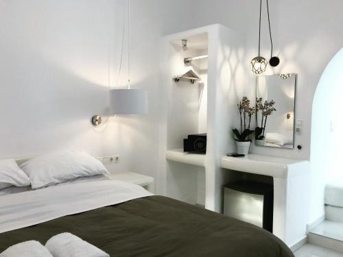 a white bedroom with a bed and a mirror at Taki's Guests in Naxos Chora