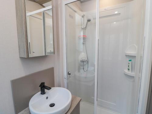 a white bathroom with a sink and a shower at Dreams & Streams in Morpeth