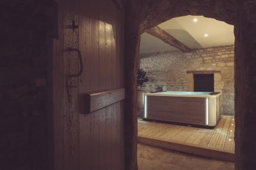 a view of a room with a tub in a stone wall at La Villa Celestine in Chablis