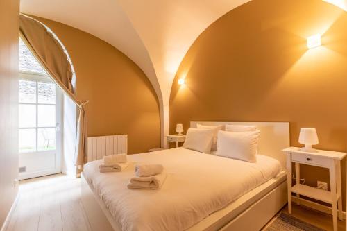 een slaapkamer met een bed met twee handdoeken erop bij LES VOÛTES DE SATURNIN in Saint-Saturnin