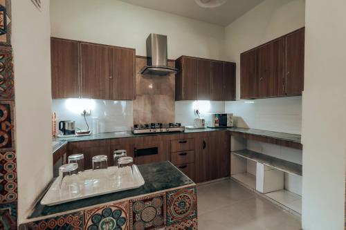a kitchen with wooden cabinets and a counter top at Ceedar Cottages in Bhīm Tāl