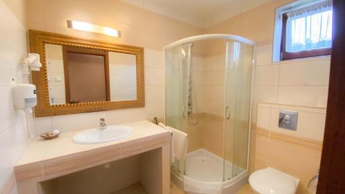 a bathroom with a sink and a shower and a toilet at Bajor Panzió Bük-Bükfürdő, Adults Friendly 12 Plus in Bük