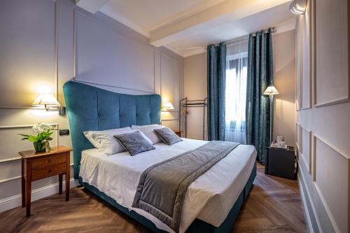 a bedroom with a large bed with a blue headboard at Boutique Hotel Borgo in Florence