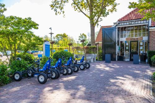 een rij blauwe scooters geparkeerd voor een gebouw bij EuroParcs Buitenhuizen in Velsen-Zuid